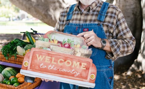 a bearded man smiling while standing near the cart with woven baskets