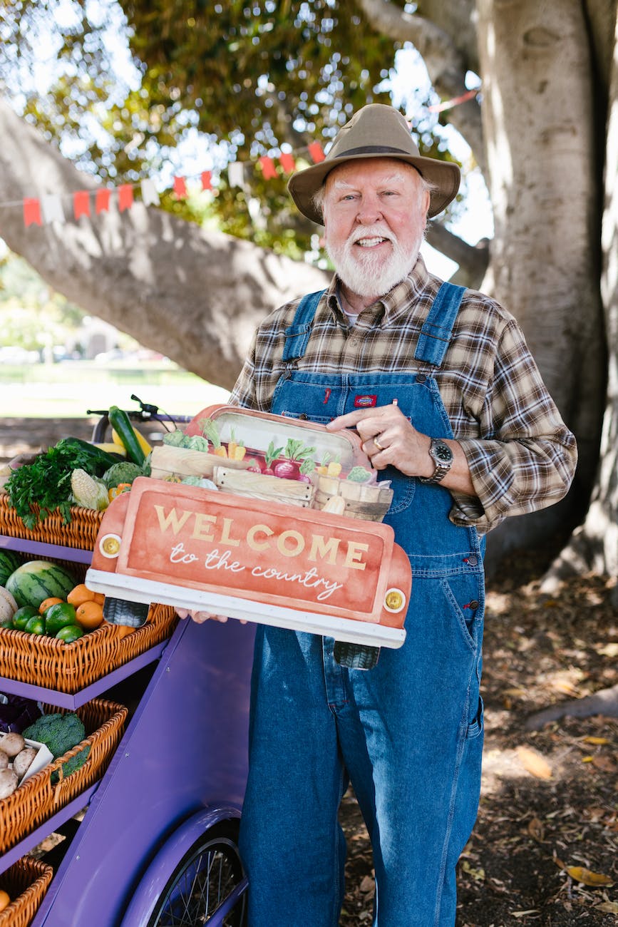 a bearded man smiling while standing near the cart with woven baskets